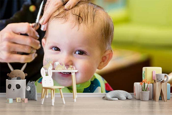 Smiling baby cutting hair shown in a room