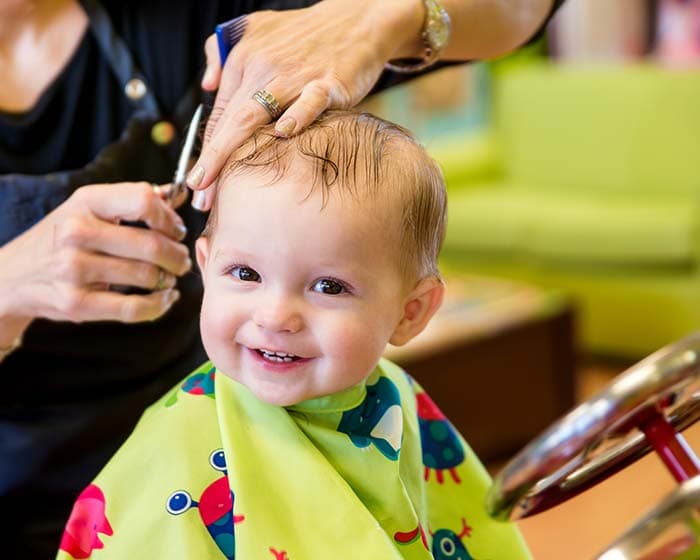 Smiling baby cutting hair pattern detail