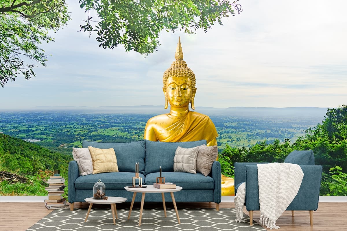 A golden statue of a person sitting on a hill shown in a room