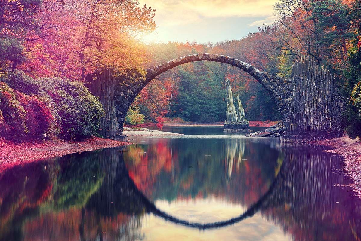A bridge over water with trees and a small statue pattern detail