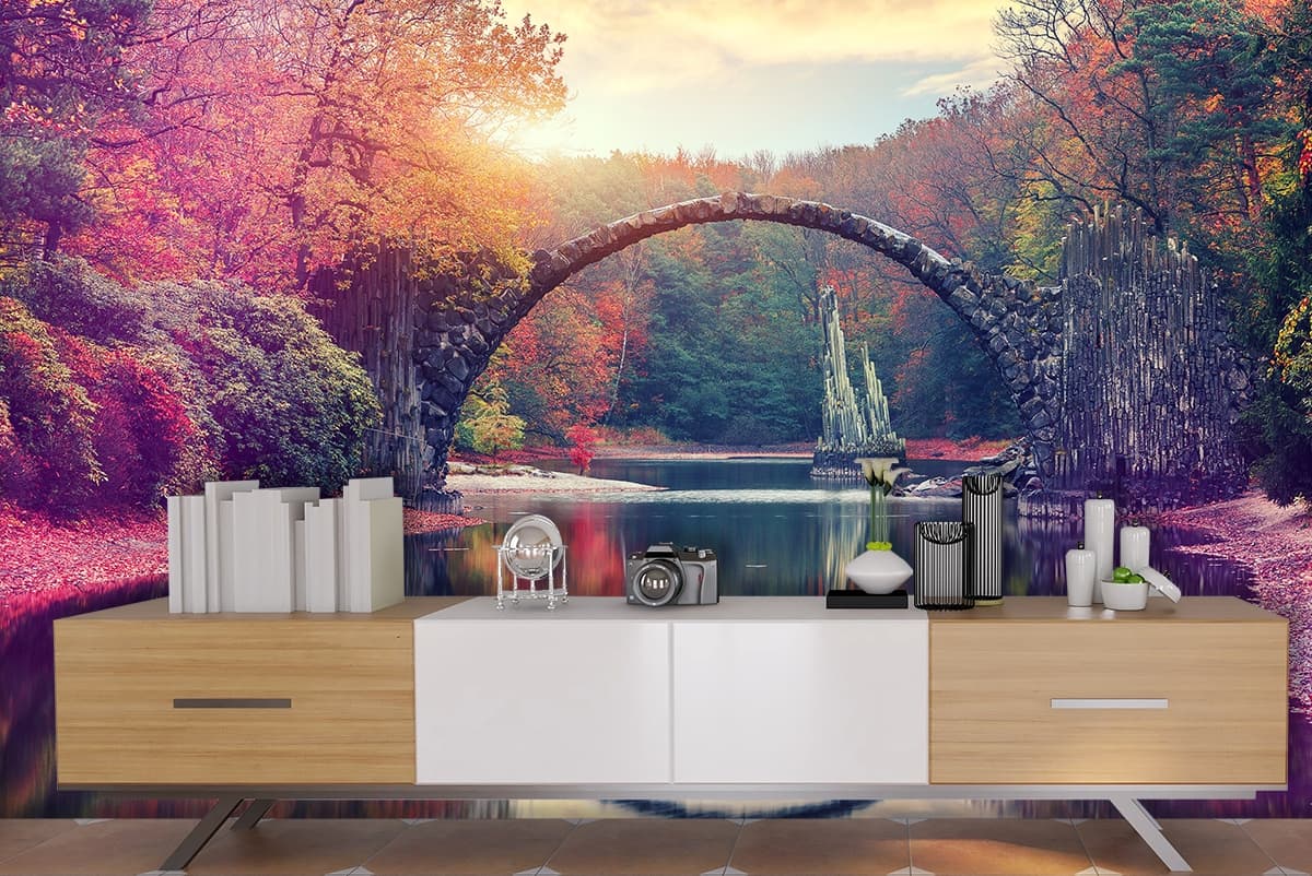 A bridge over water with trees and a small statue shown in a room