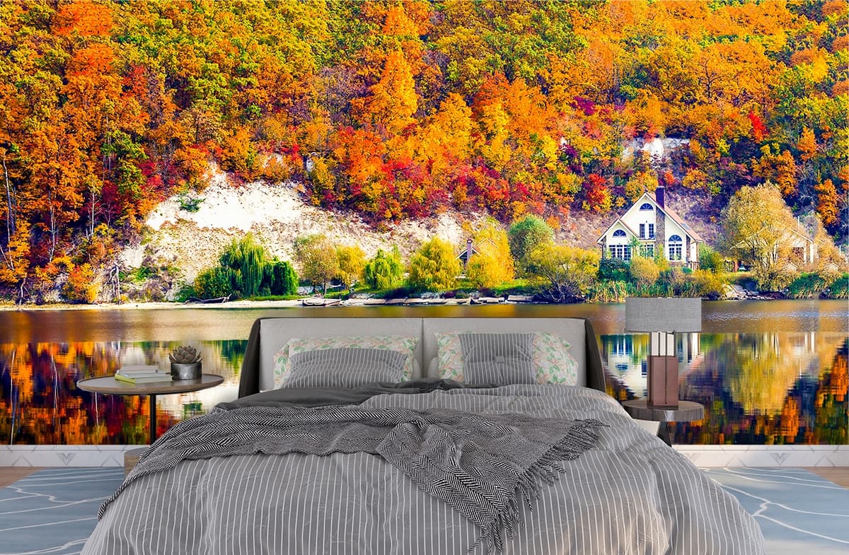 A house on the shore of a lake with trees and a hill shown in a room