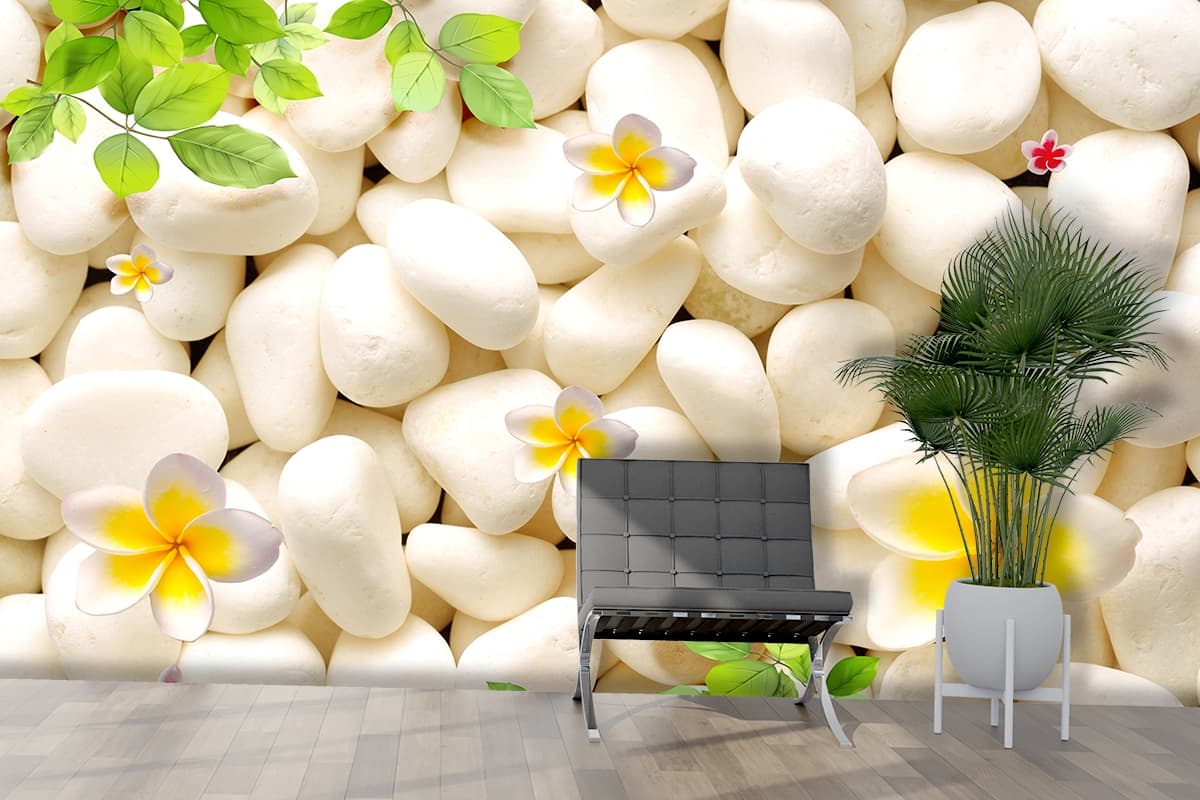 A group of white rocks with flowers and leaves shown in a room