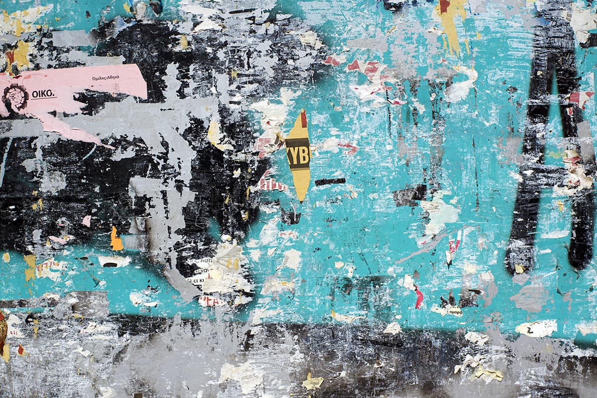 A blue wall with torn posters pattern detail